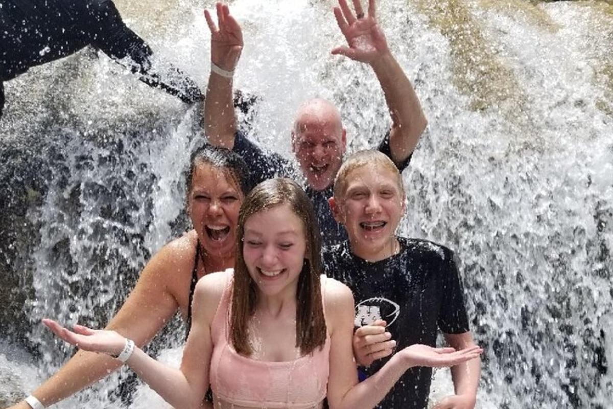 un grup de persones posant davant d'una cascada