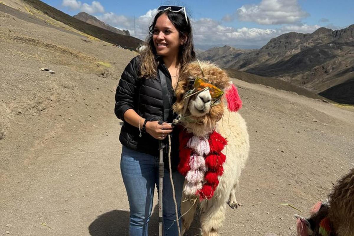 uma mulher está segurando uma lhama em uma montanha