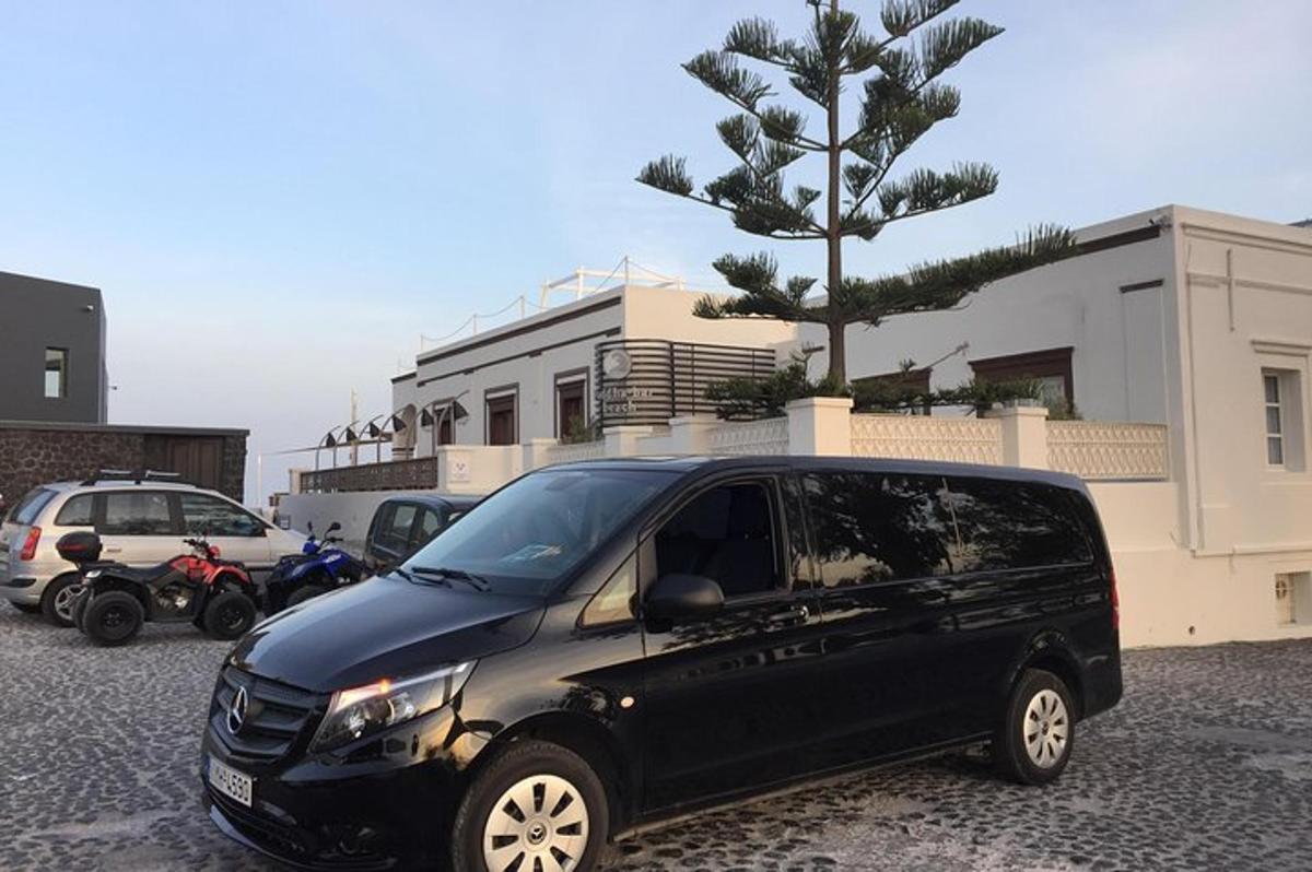 un furgone nero parcheggiato in un parcheggio accanto a un albero