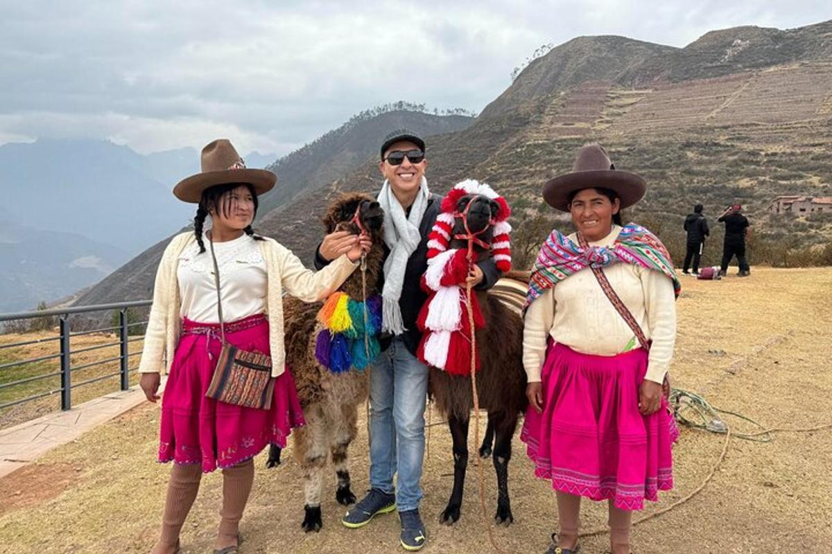 um homem e três mulheres em pé ao lado de um camelo