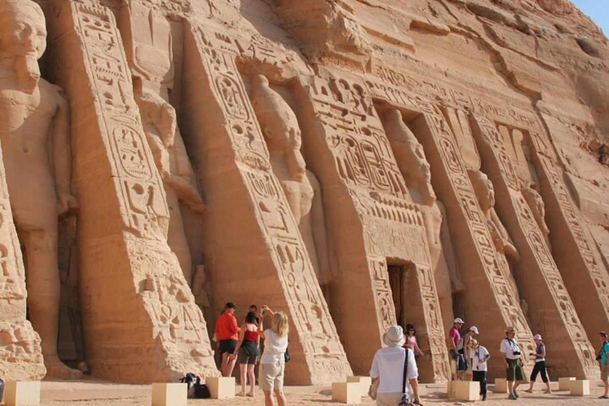 un gruppo di persone in piedi davanti ad Abu Simbel