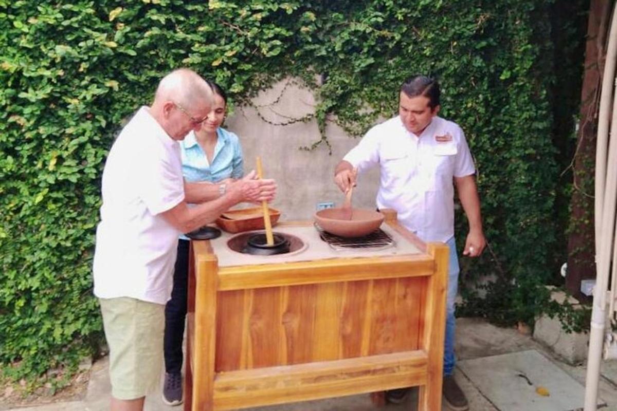 a group of three people standing around a table with a grill