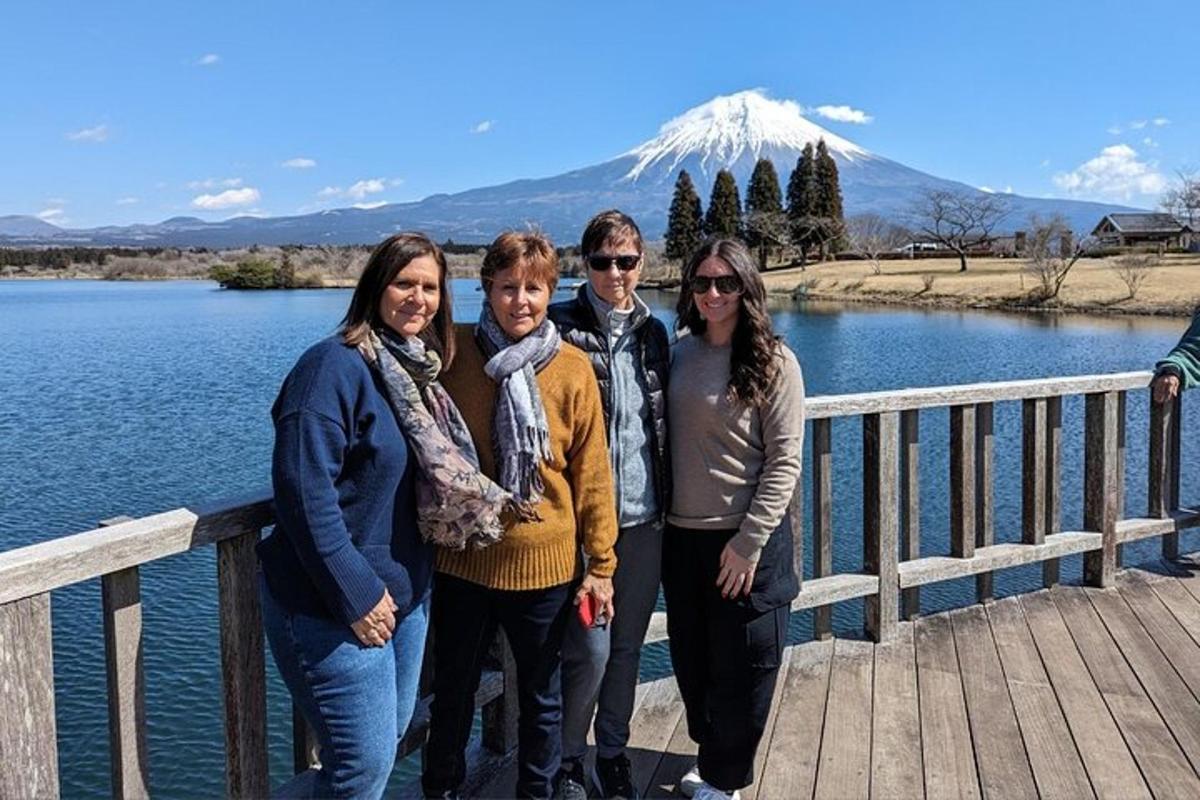 a group of people standing on a bridge with a mountain in the background