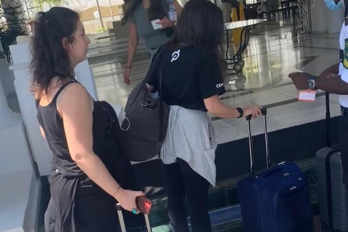 dua wanita menunggu bagasi mereka di lapangan terbang