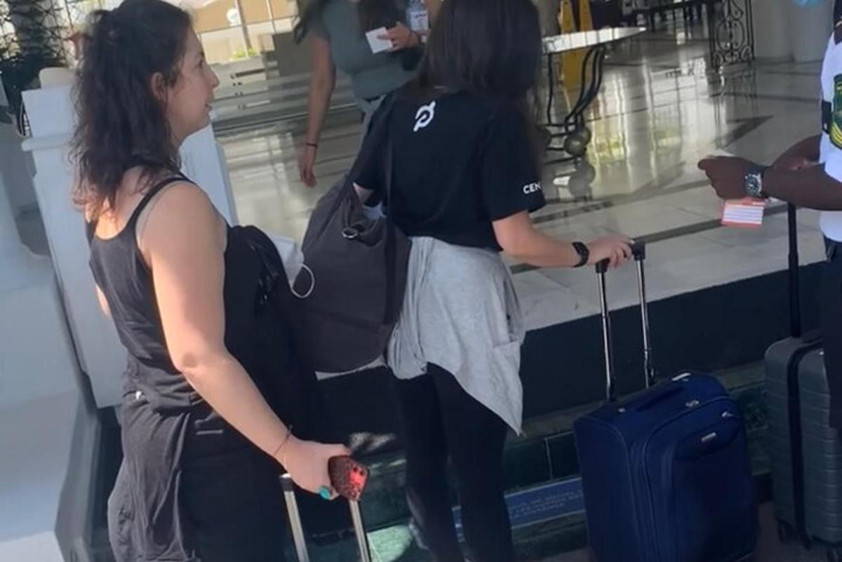 dve ženski čakata na svojo prtljago na letališču