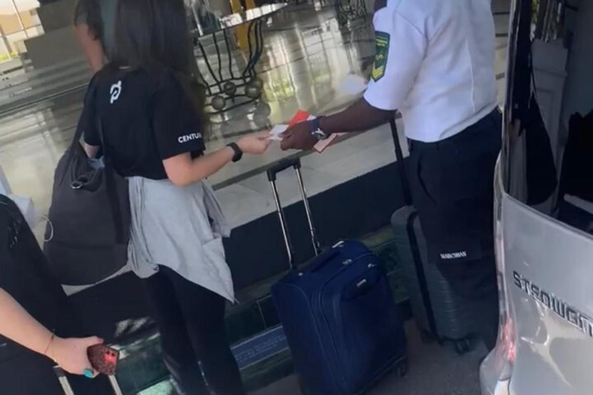 a man and woman standing next to a luggage cart