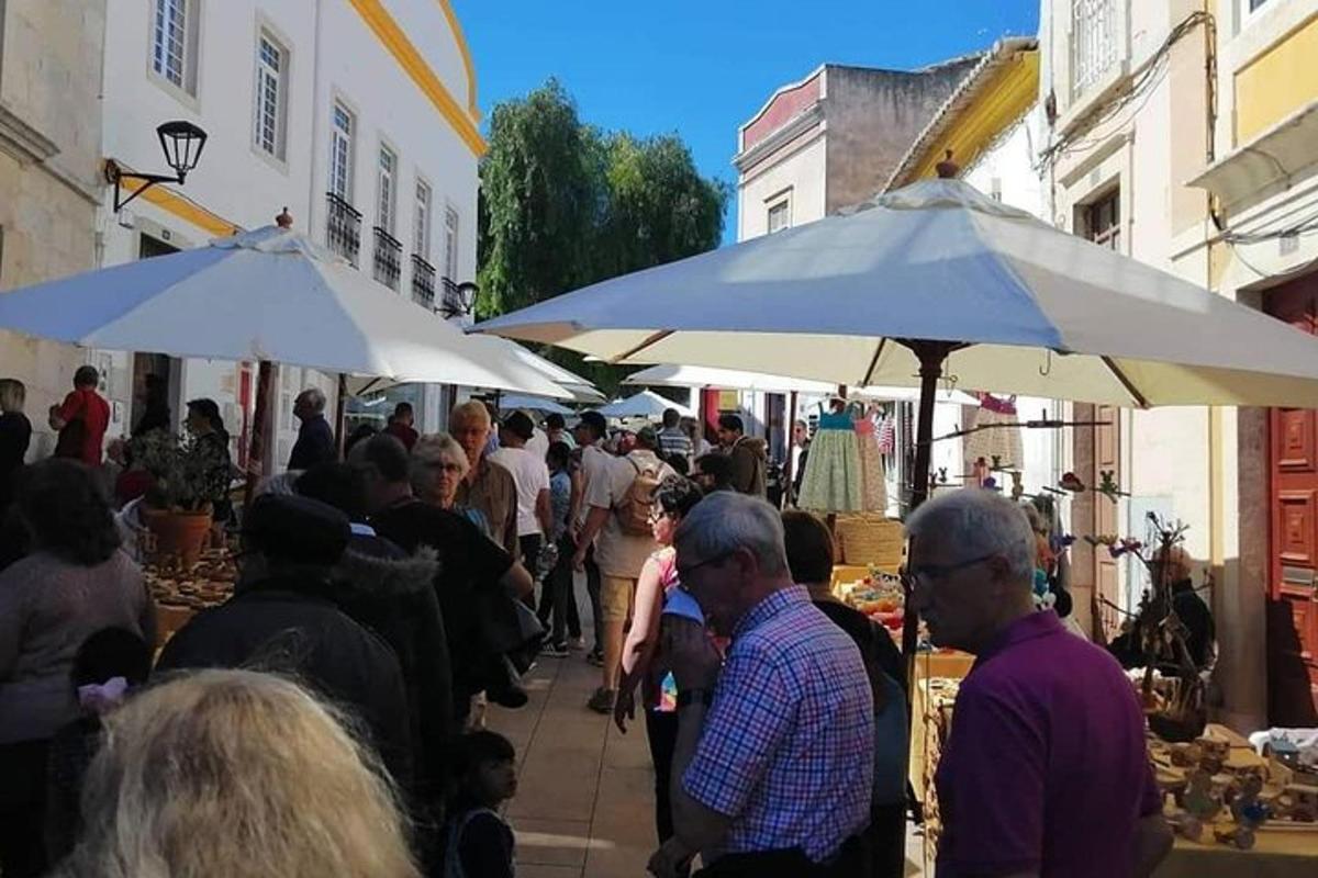 skupina lidí procházejících se po trhu s deštníky