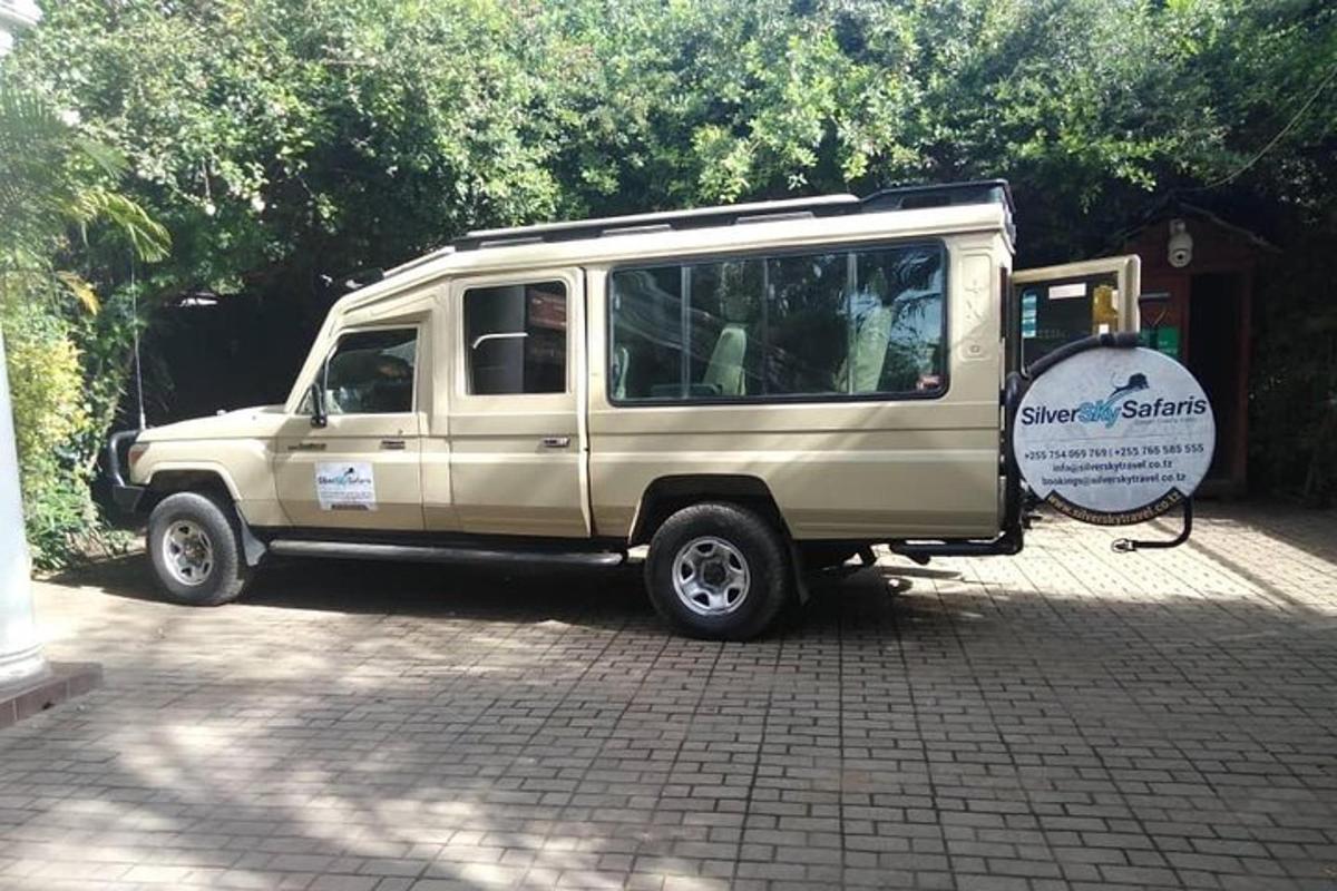 một chiếc xe tải màu nâu đậu trong đường lái xe có biển báo