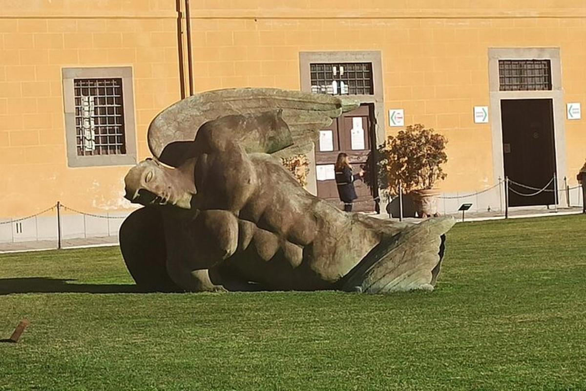 uma estátua na grama em frente a um prédio