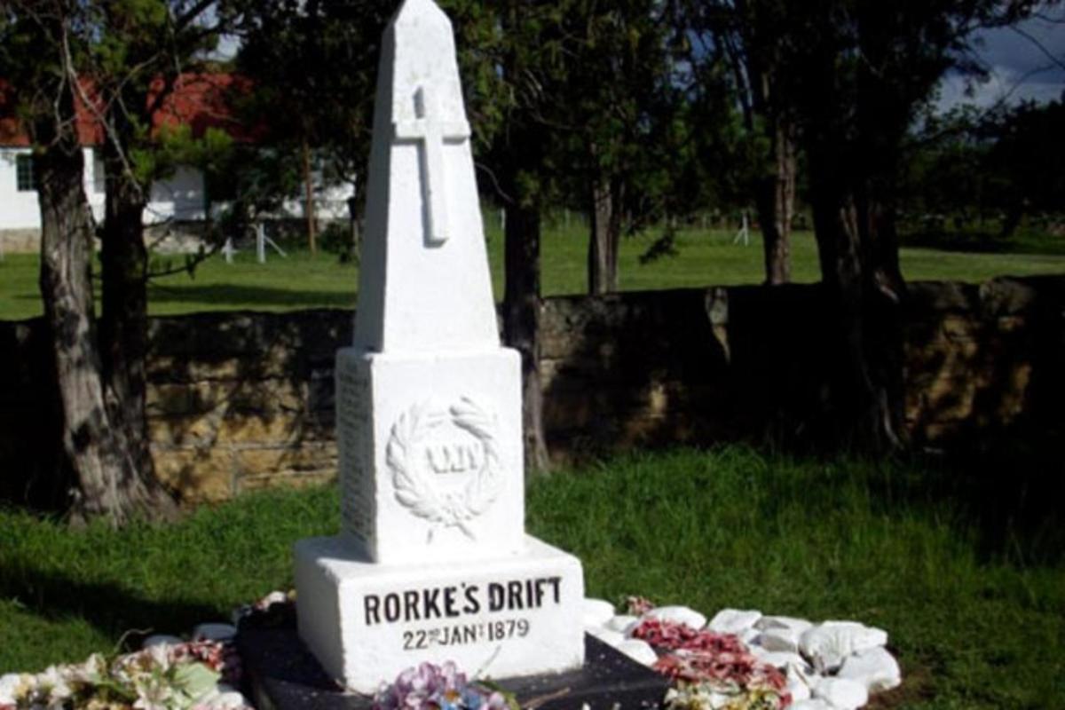 spomenik na pokopališču s cvetjem v travi