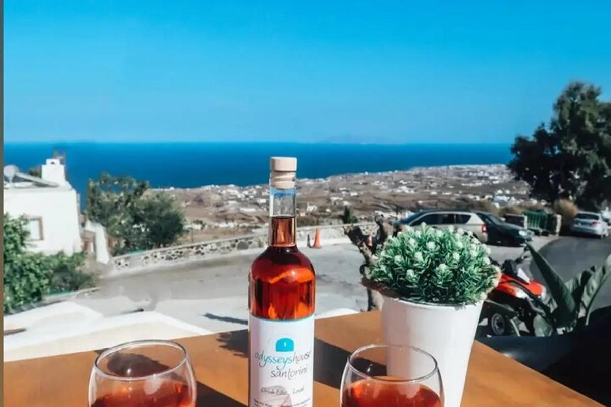 Ένα μπουκάλι κρασί κάθεται σε ένα τραπέζι με δύο ποτήρια