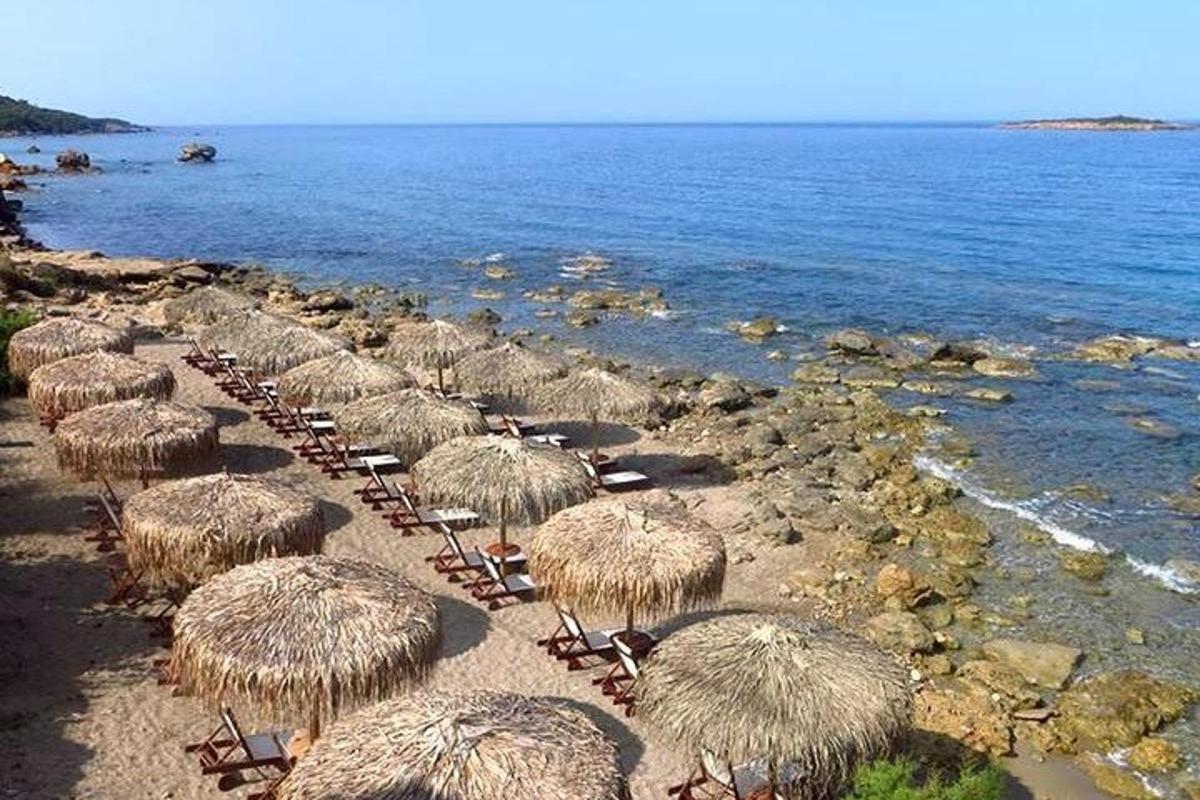 a group of straw umbrellas and chairs on a beach