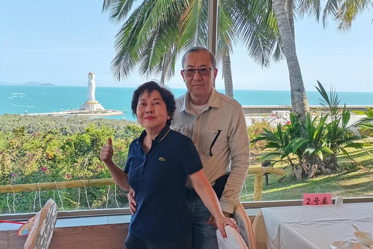 a man and a woman standing in front of the ocean