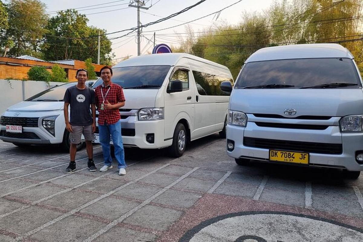 two men standing in front of two white vans