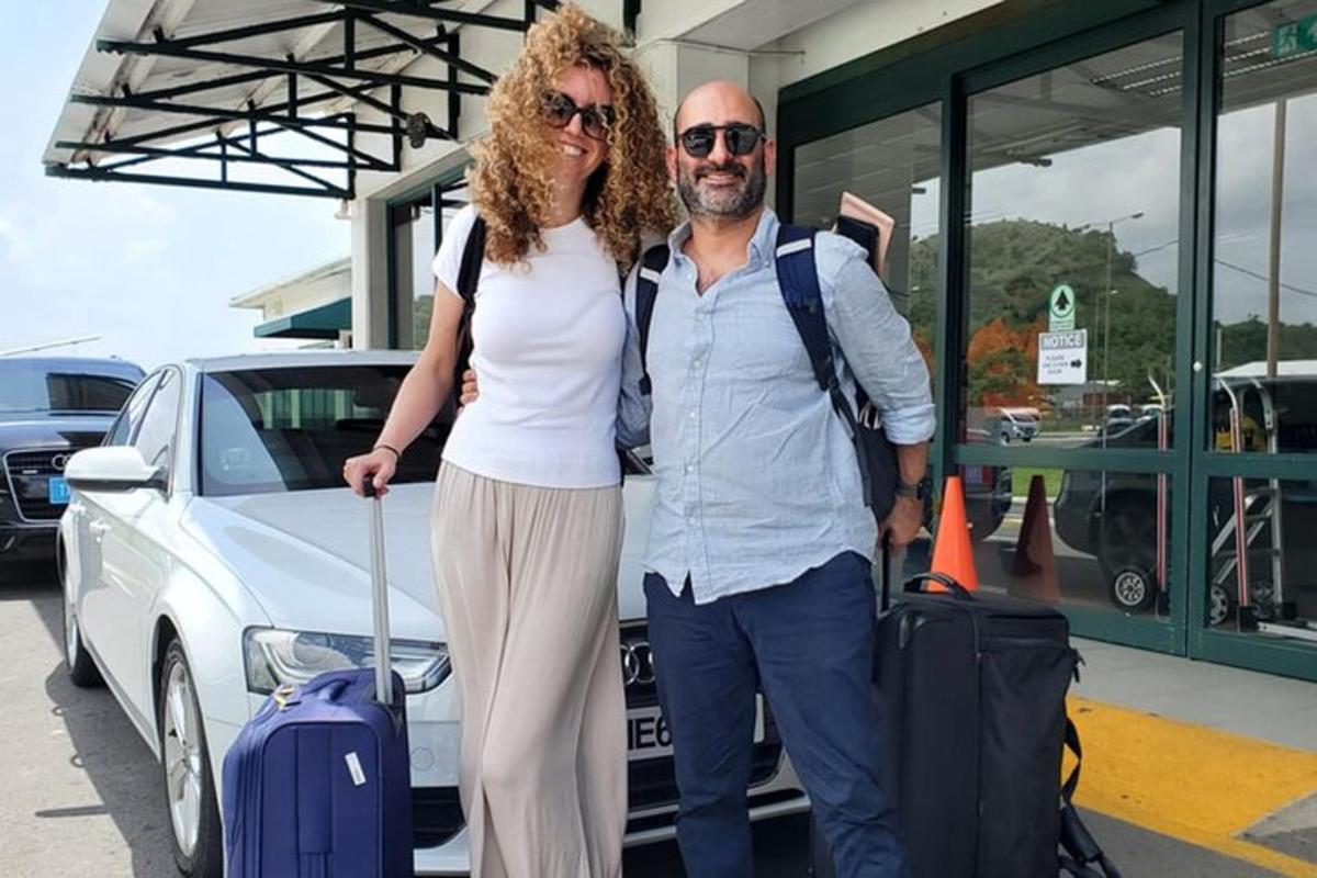 un uomo e una donna in piedi accanto a un'auto con i bagagli