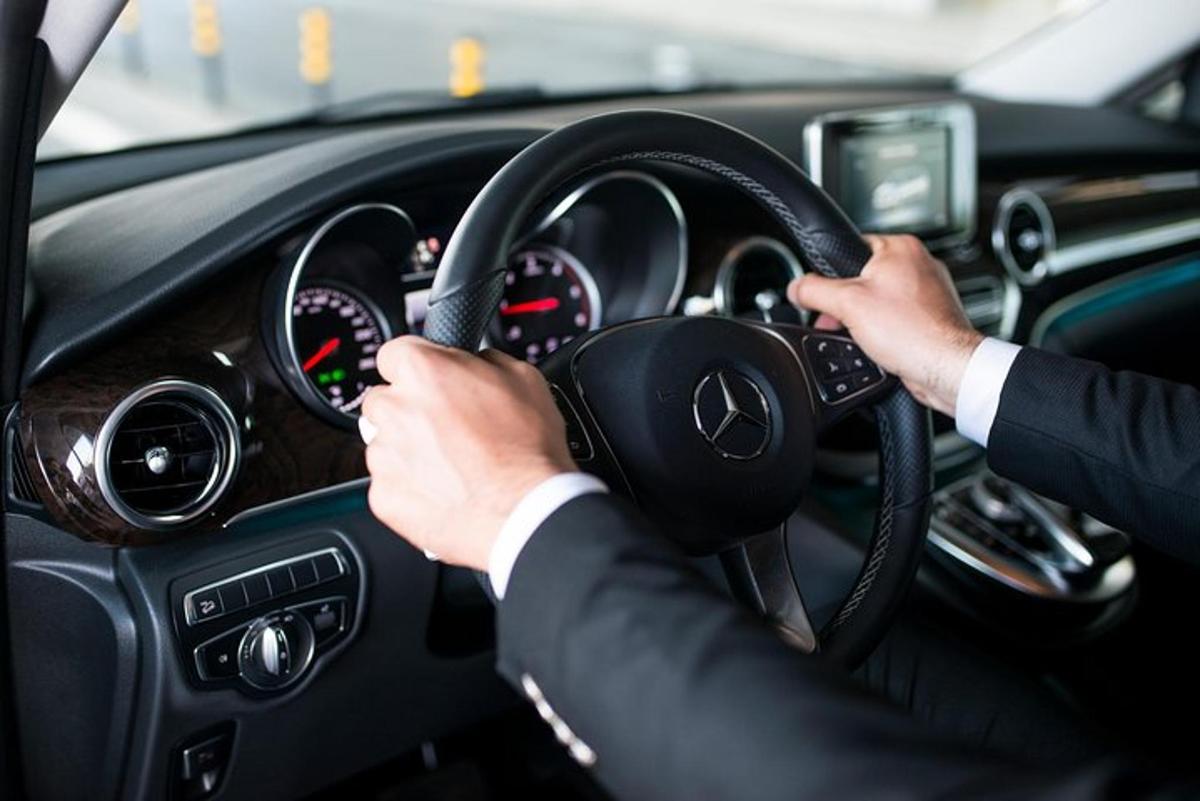 mees, kes juhib autot käed roolil