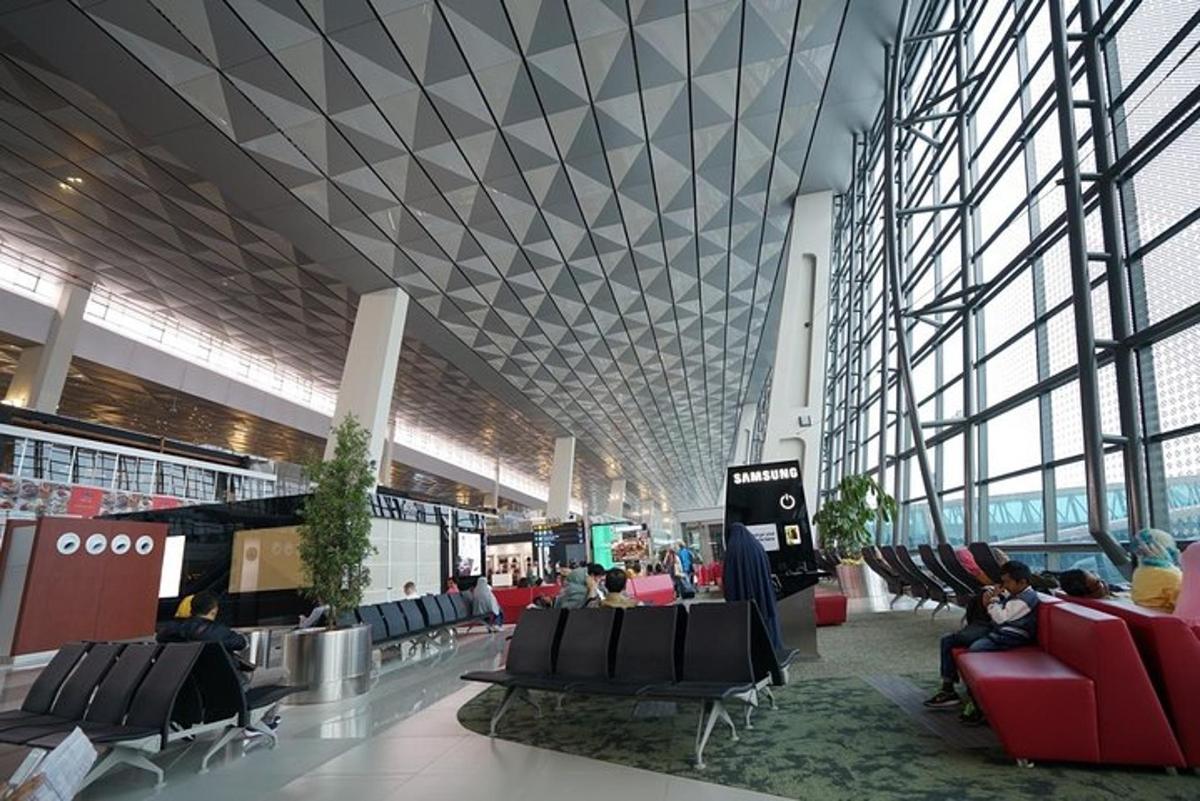een grote terminal met mensen die op stoelen in een gebouw zitten