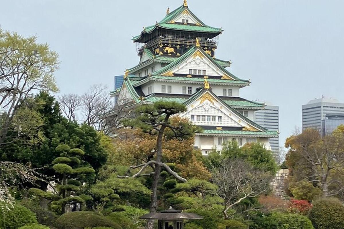 Un gran edificio con un árbol delante.