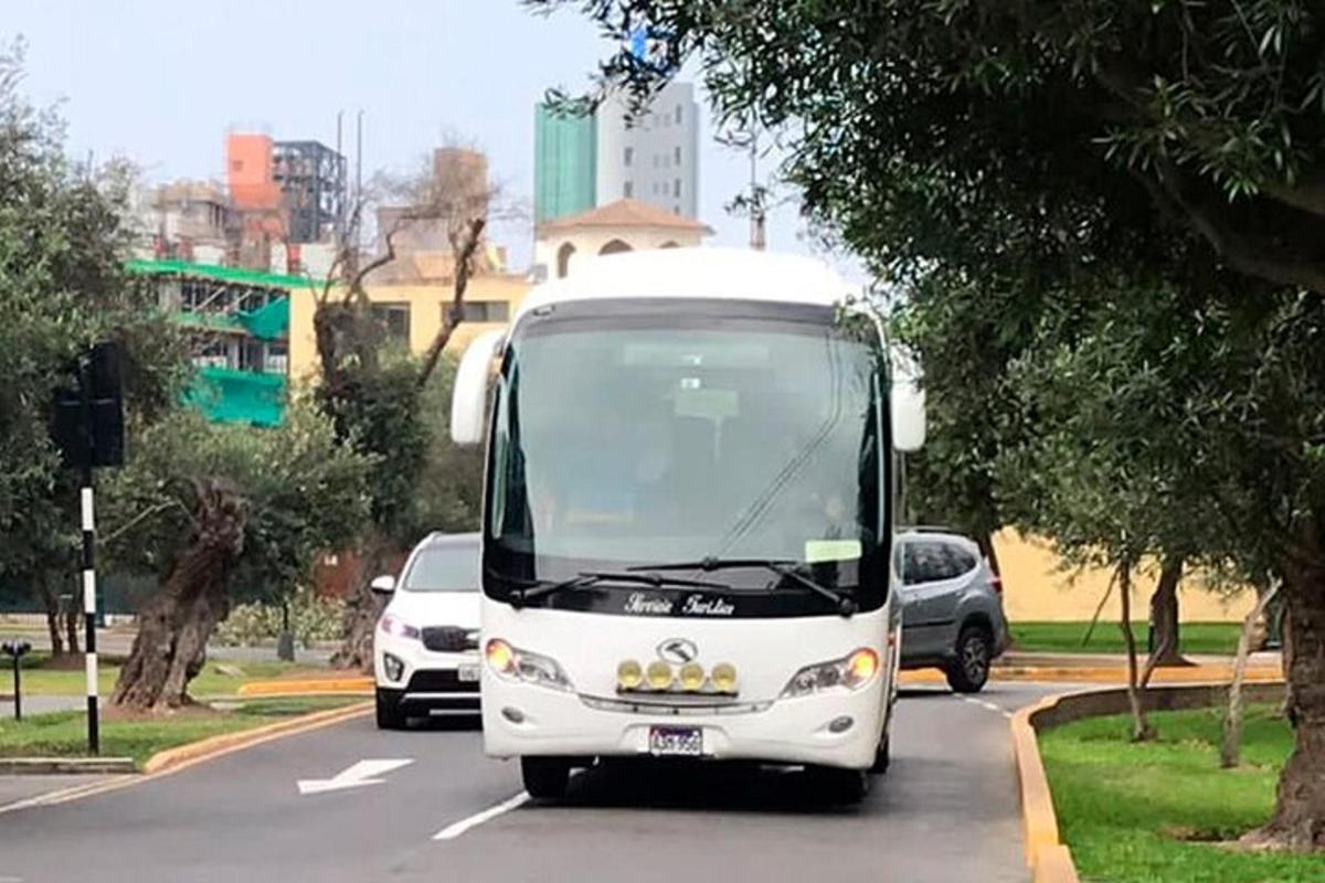 un autobuz alb circulă pe o stradă plină de mașini
