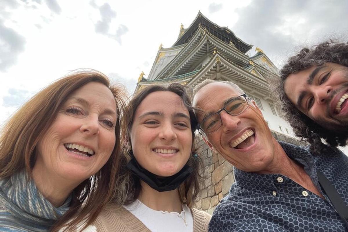 Tres personas posando para una foto frente a un edificio.