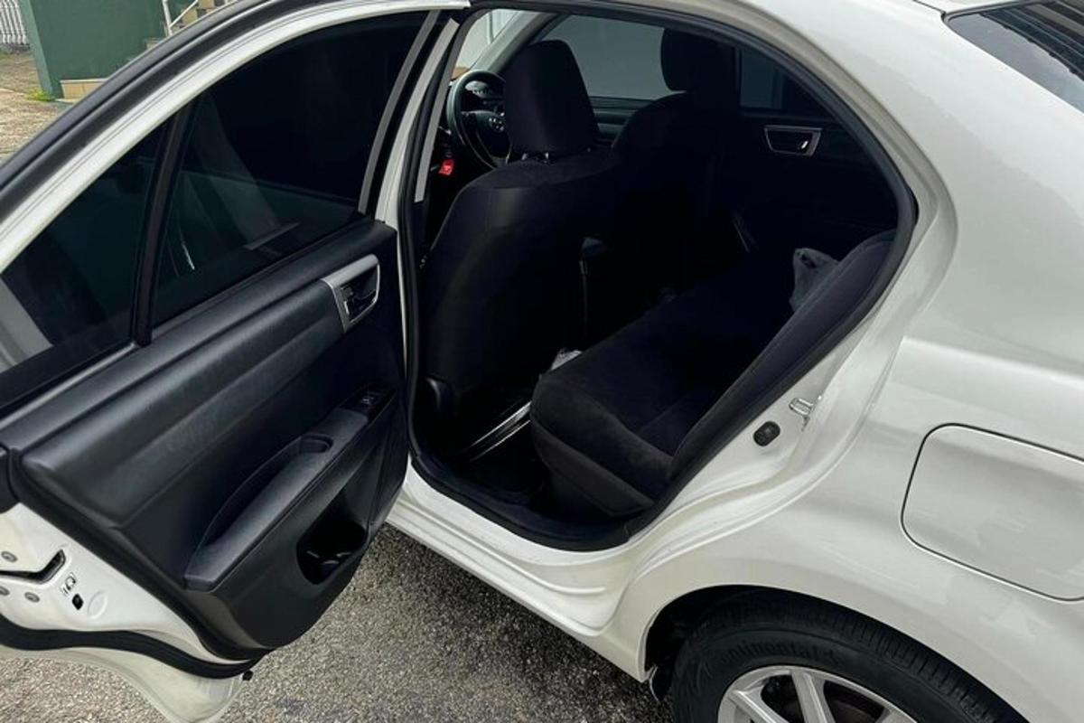 a white car with its door open in a parking lot