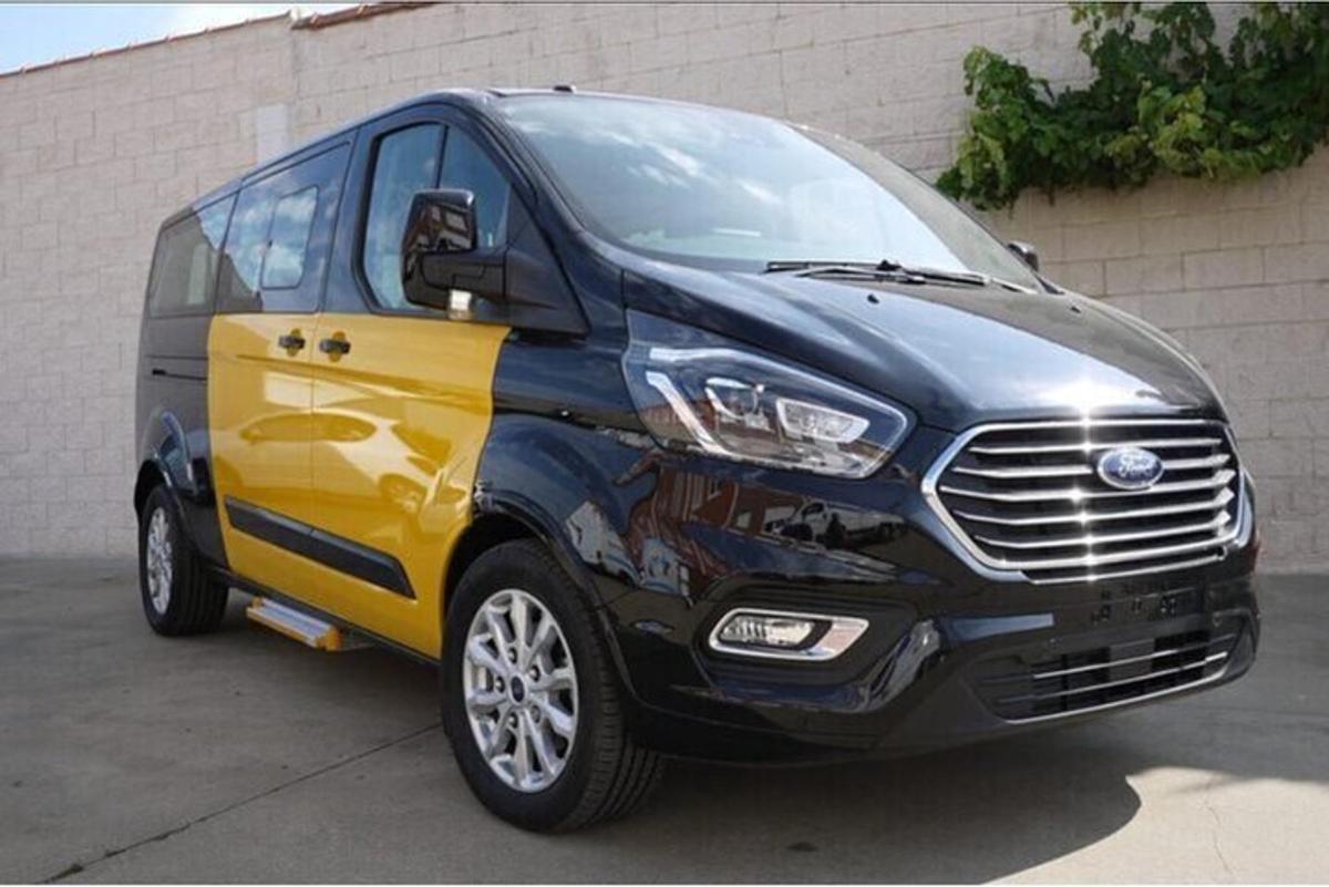 uma van preta e amarela estacionada ao lado de um prédio