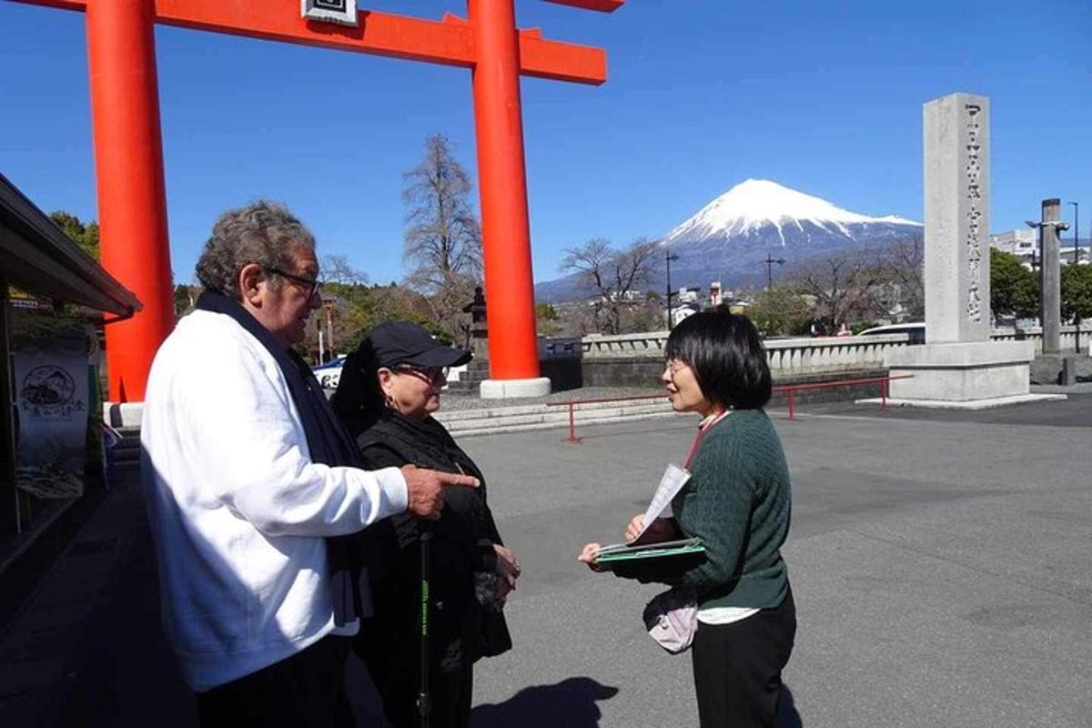 a man talking to two women in front of a mountain