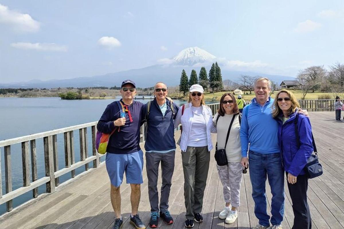 a group of people standing on a bridge with a mountain in the background