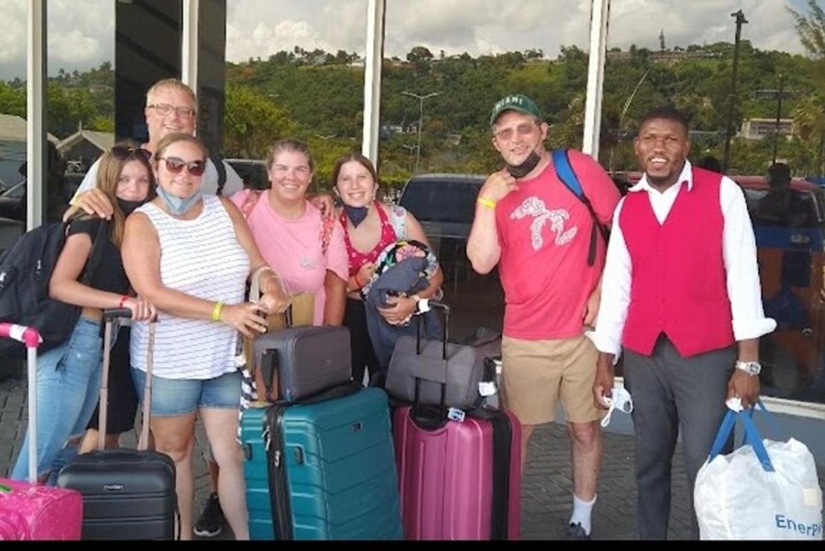 un grup de persones posant per a una foto amb el seu equipatge