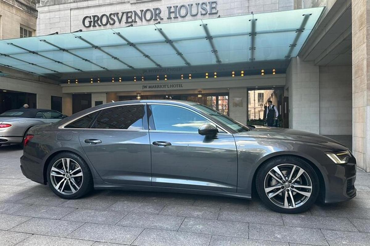 um carro prateado estacionado em frente a um prédio