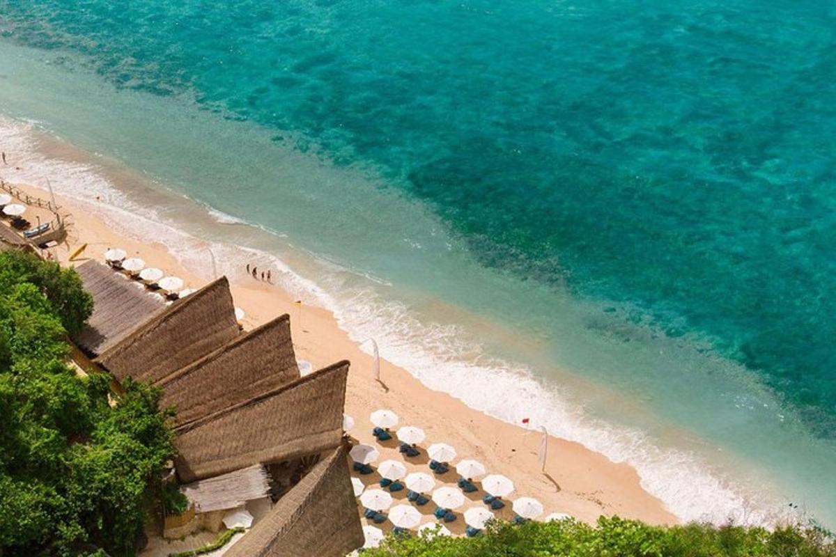 an aerial view of a beach with umbrellas and the ocean