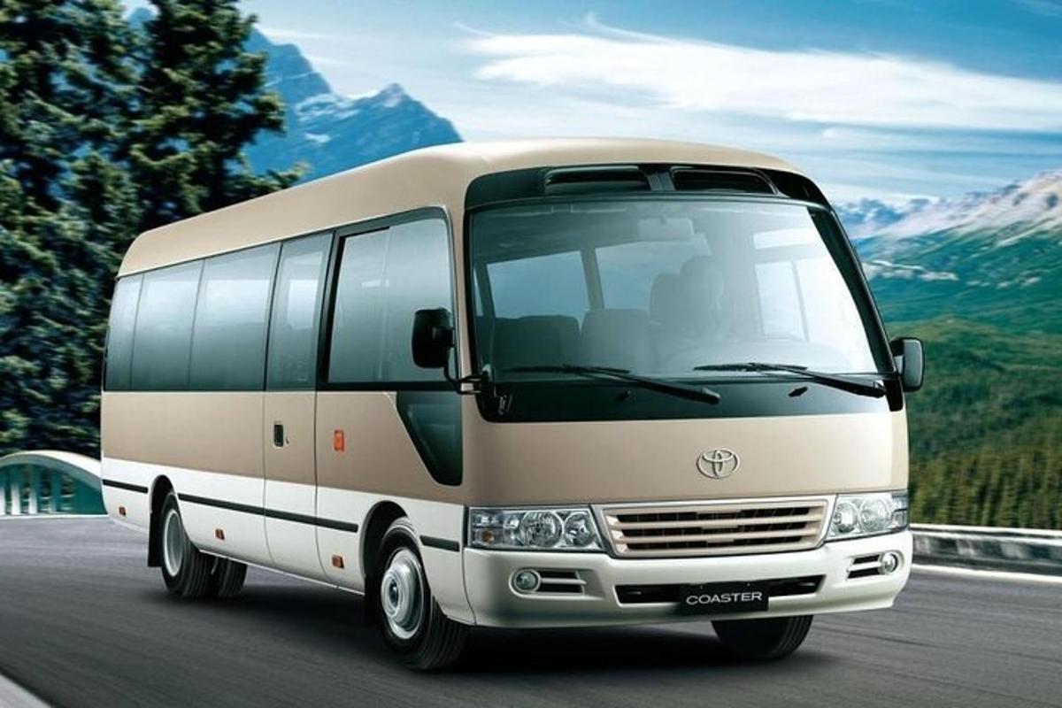 a white bus driving down a road