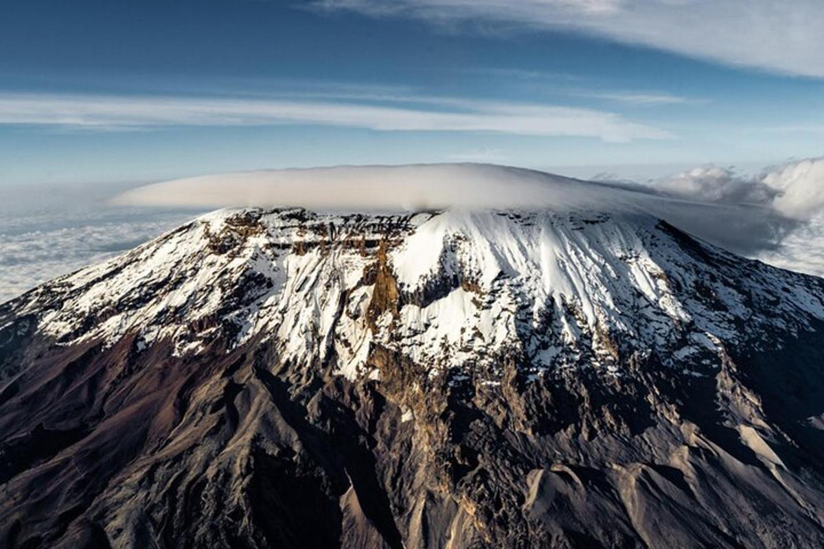 uma montanha coberta de neve com uma nuvem no topo