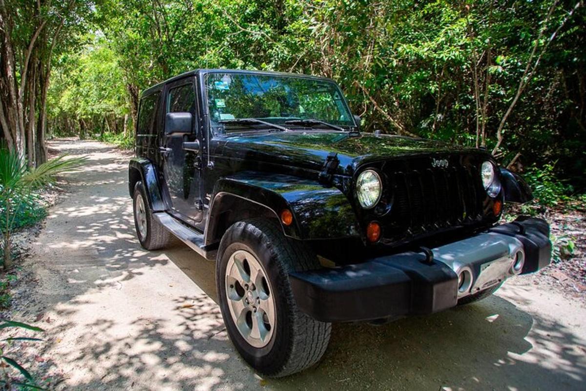 a black jeep parked on a dirt road