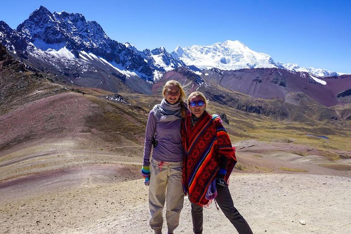 dos mujeres de pie en la cima de una montaña