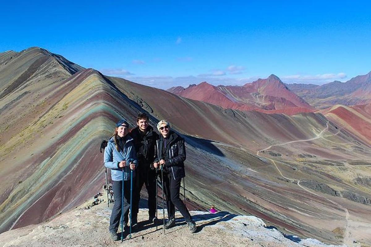 tres personas de pie en la cima de una montaña