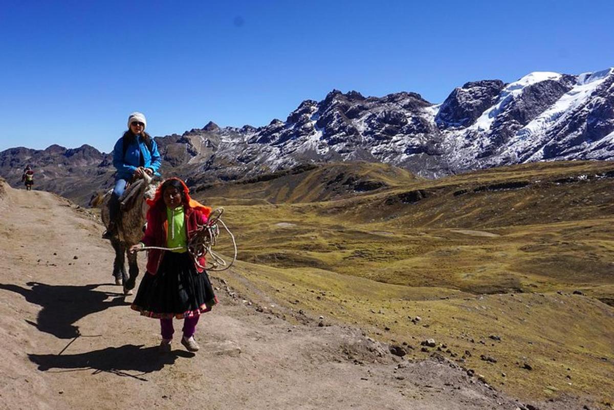 Un hombre y una mujer montando a caballo en una montaña