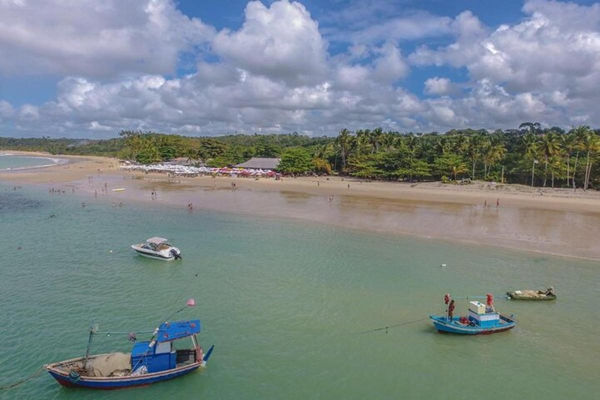 two boats in the water next to a beach