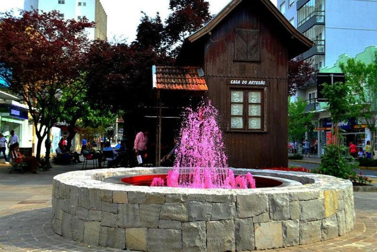 a fountain with pink water in front of a building