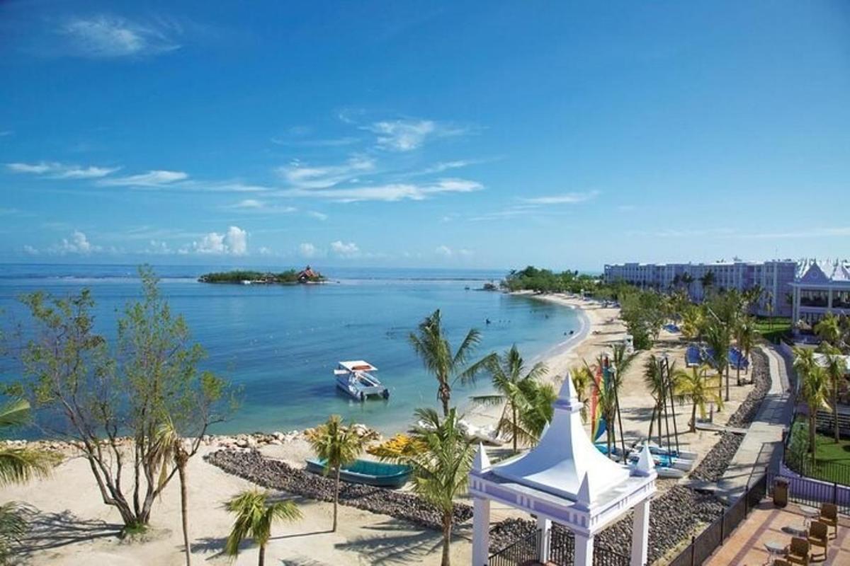 pemandangan pantai dengan bot di dalam air