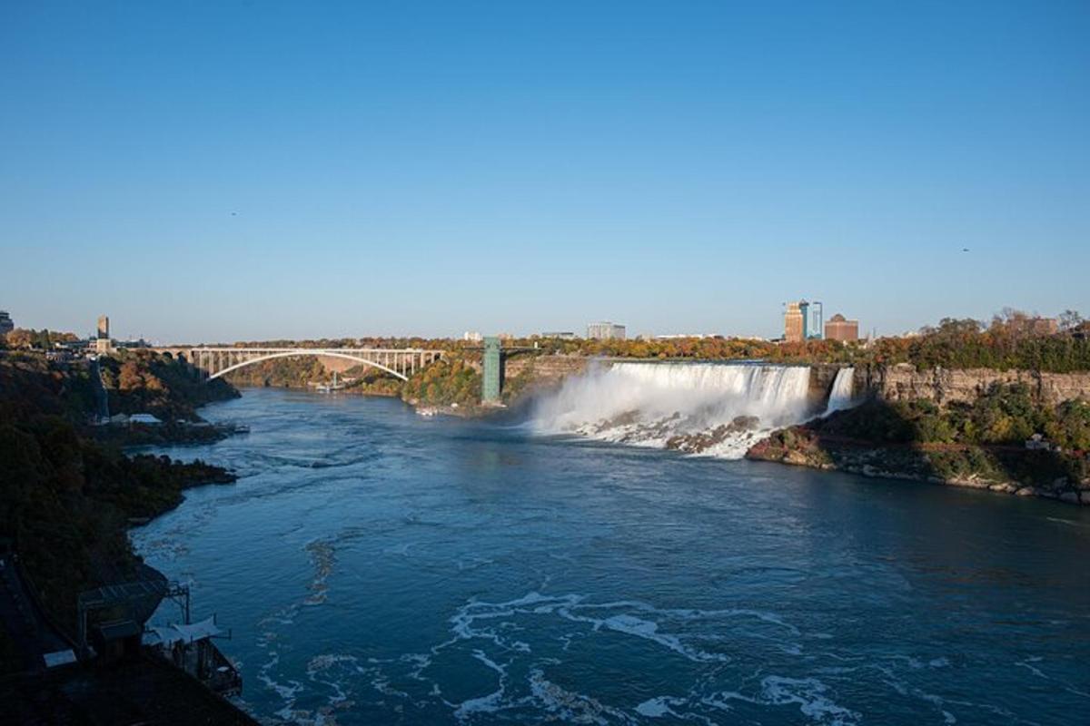a river with a waterfall and a bridge