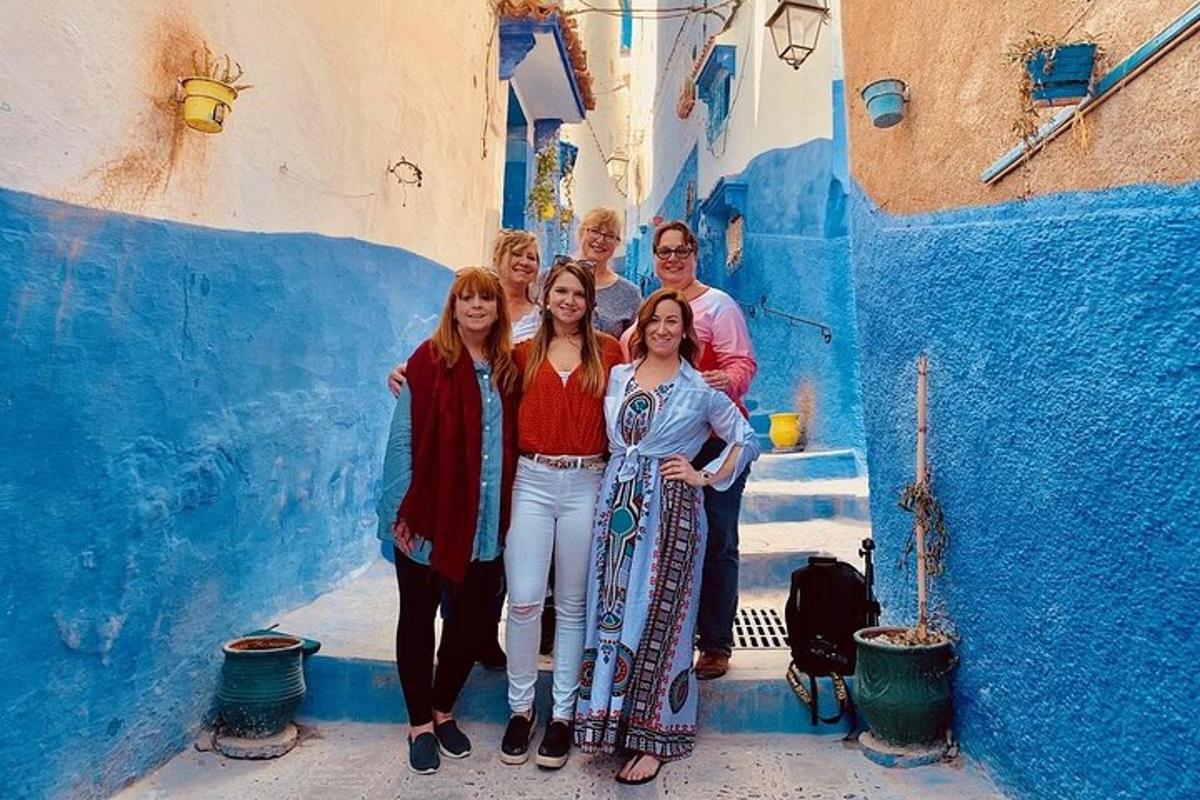 um grupo de pessoas posando para uma foto em um beco azul