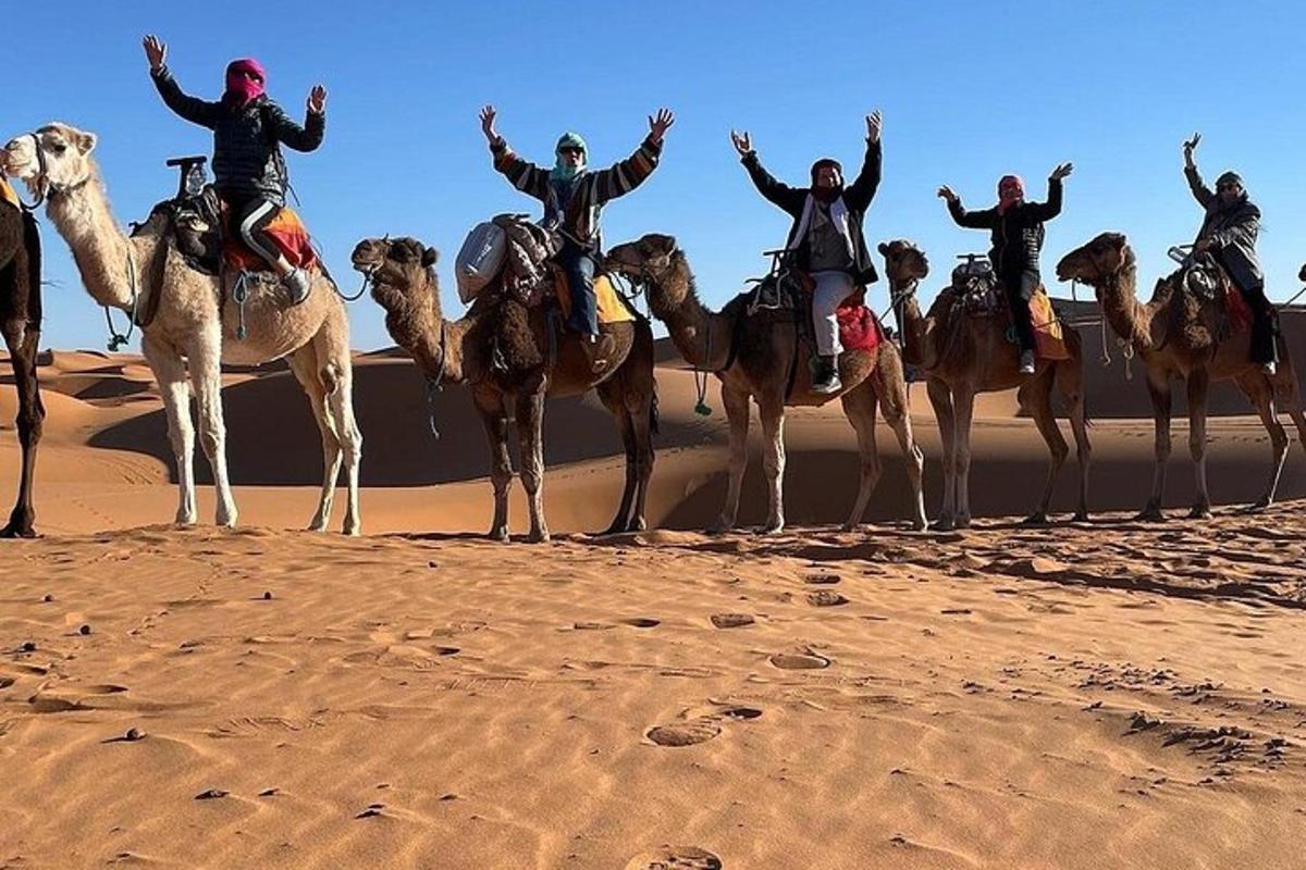 um grupo de pessoas em camelos no deserto