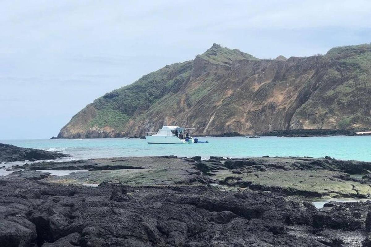 a boat in the water next to a mountain