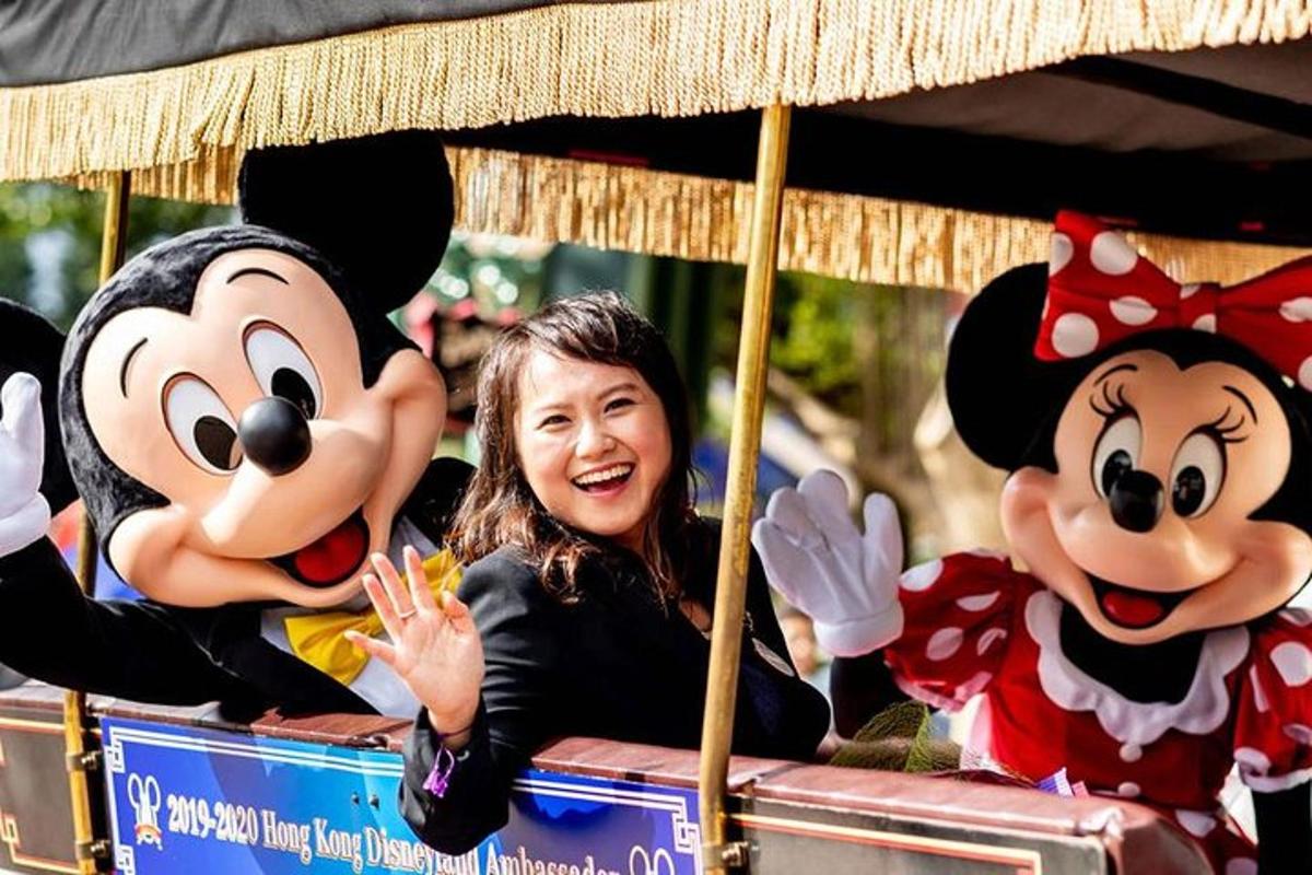 una donna che viaggia su un carrello in costume da Topolino