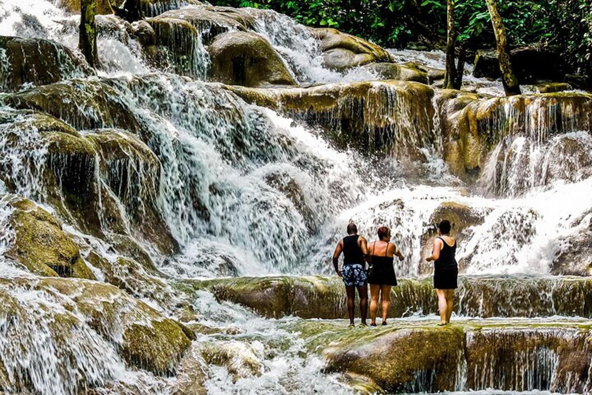 tre persone in piedi davanti a una cascata