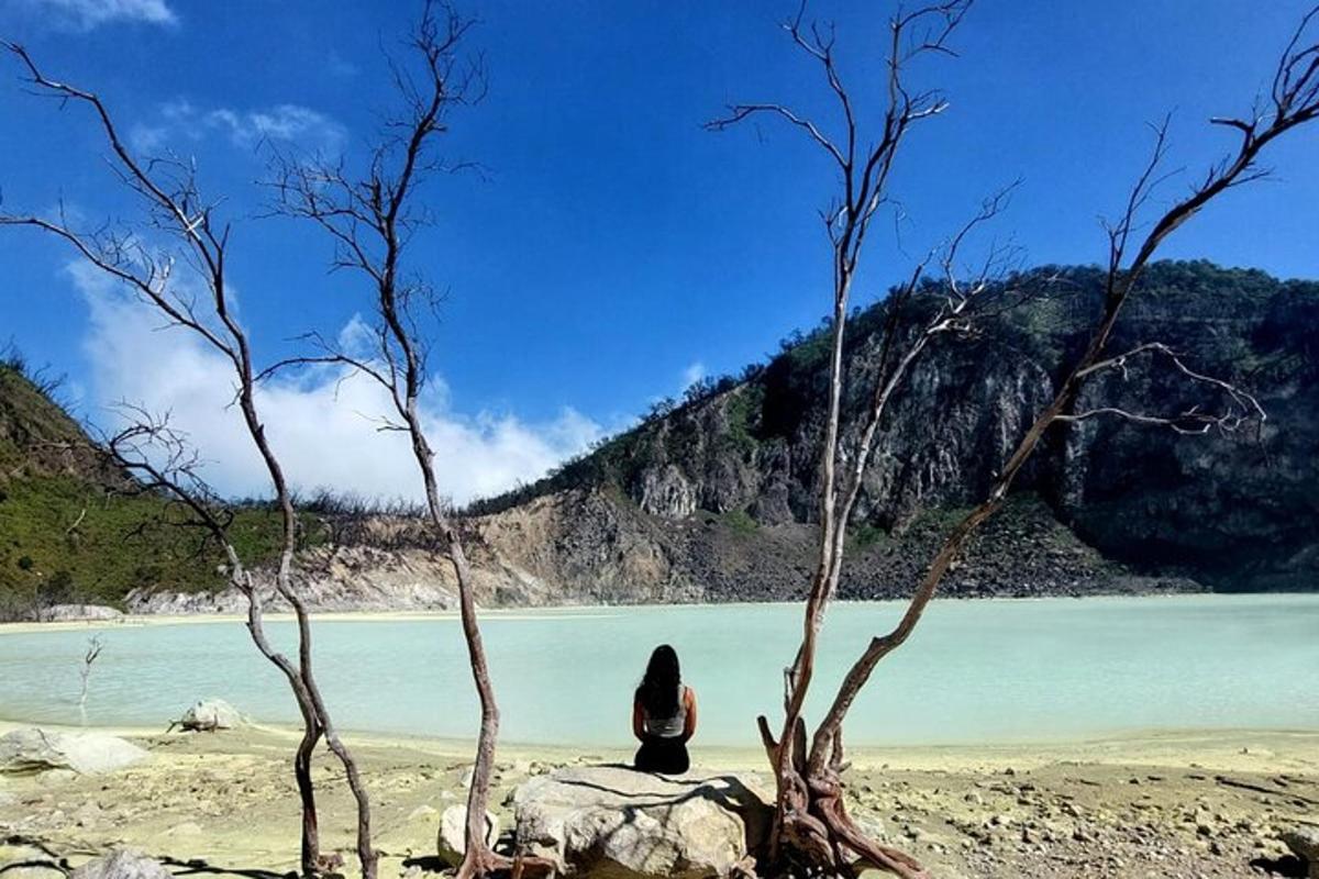 a woman sitting on a beach near a body of water