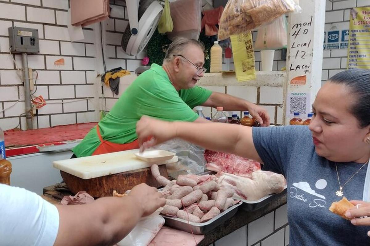 two women are preparing meat at a market