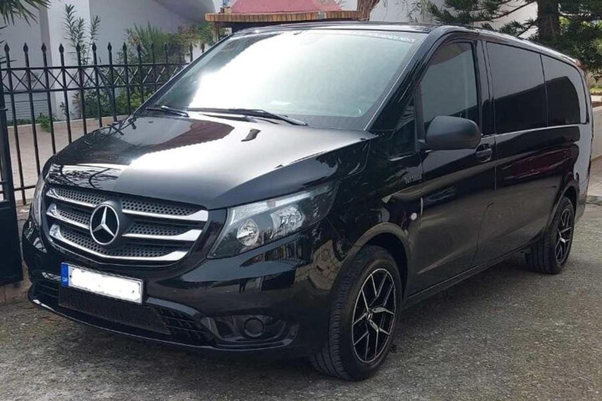 Svartur Mercedes Benz sendibíll lagður við girðingu