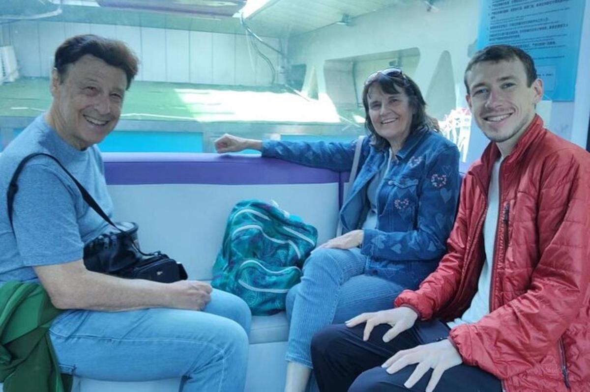 two men and a woman sitting on a train